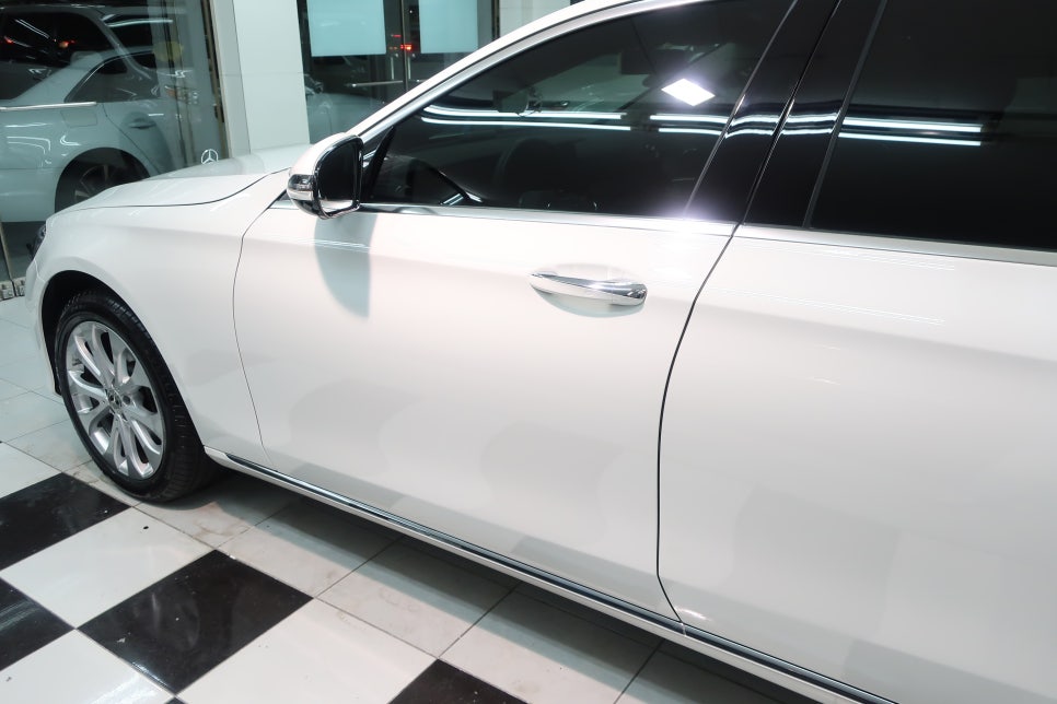 벤츠 E220d 폴라 화이트 차량의 도장면 전체에 쌓인 생활 스크래치와 묵은 이물질로 인해 광택을 잃은 상태